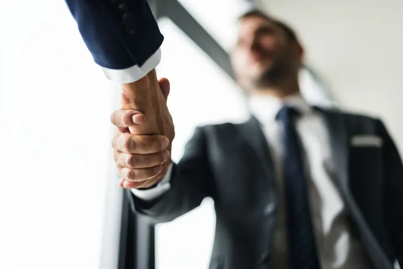 Handschlag zwischen Unternehmer und neuem Mitarbeiter